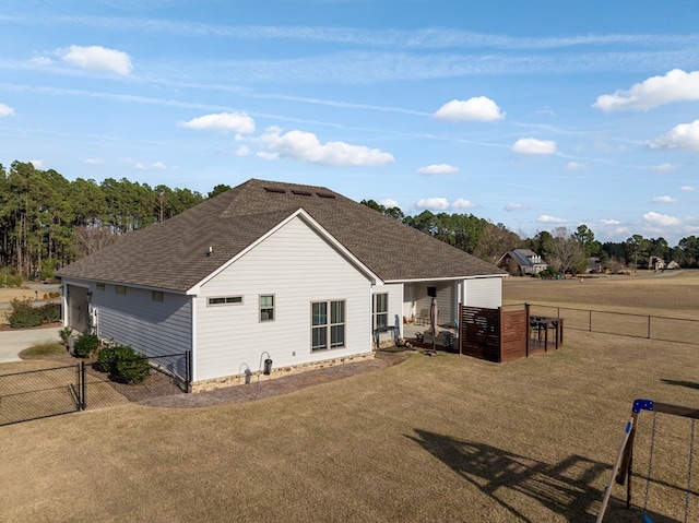 back of house with a lawn, roof with shingles, a gate, and a fenced backyard