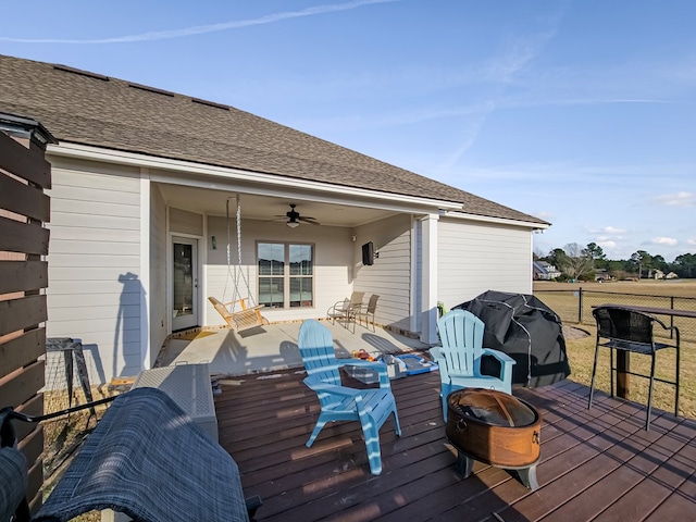 wooden terrace featuring fence, a fire pit, ceiling fan, and a grill