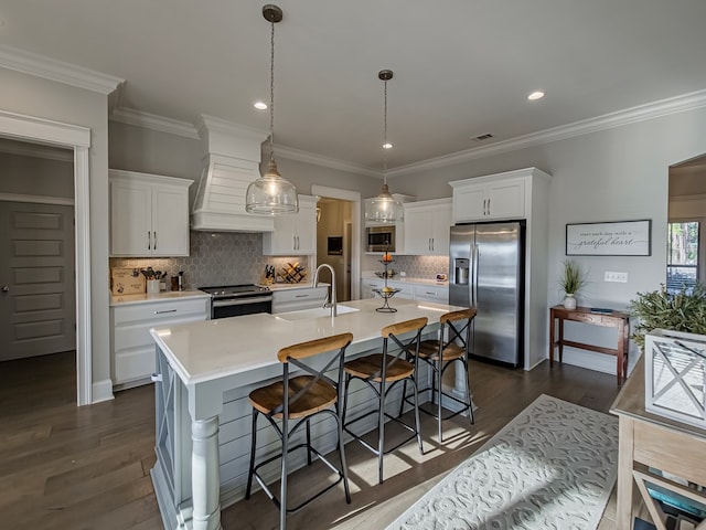 kitchen with appliances with stainless steel finishes, light countertops, white cabinets, a sink, and premium range hood