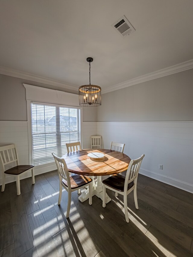 dining area featuring a chandelier, visible vents, ornamental molding, and dark wood-style flooring