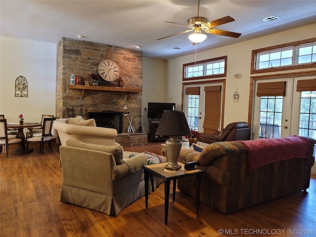 living room with dark hardwood / wood-style flooring, ceiling fan, a fireplace, and french doors