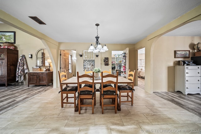 dining room with an inviting chandelier and light wood-type flooring