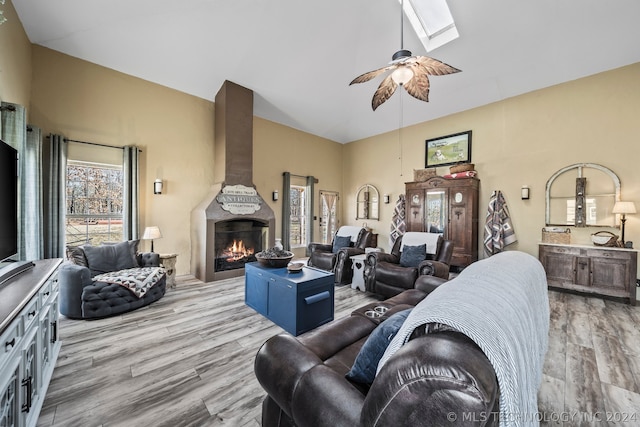 living room with a skylight, ceiling fan, and hardwood / wood-style floors