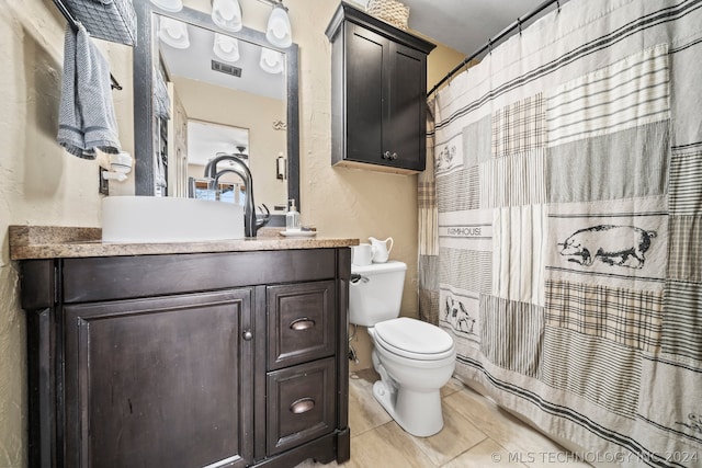 bathroom with vanity, toilet, and tile patterned floors