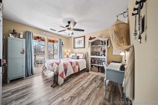 bedroom featuring a textured ceiling, hardwood / wood-style flooring, and ceiling fan