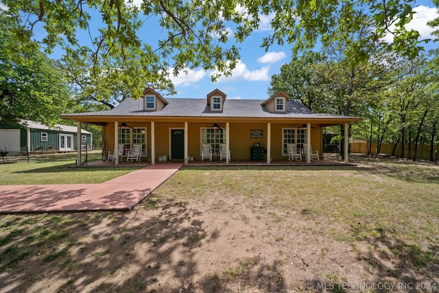 exterior space featuring covered porch and a front yard