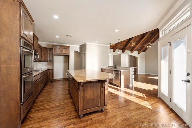 kitchen featuring light stone counters, a kitchen island, sink, and dark hardwood / wood-style floors