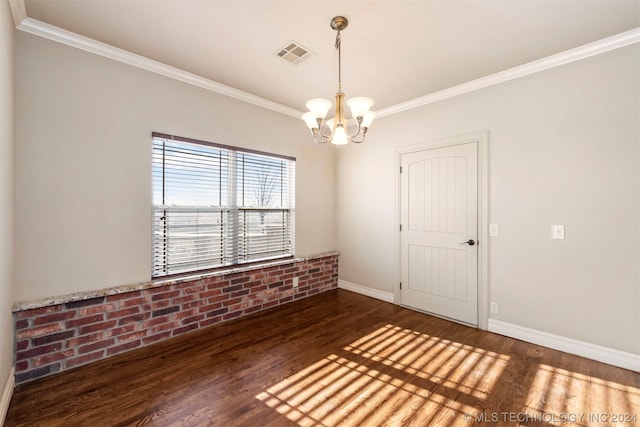 spare room featuring an inviting chandelier, dark hardwood / wood-style flooring, and ornamental molding