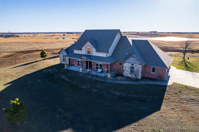 view of front facade featuring a front lawn and a rural view