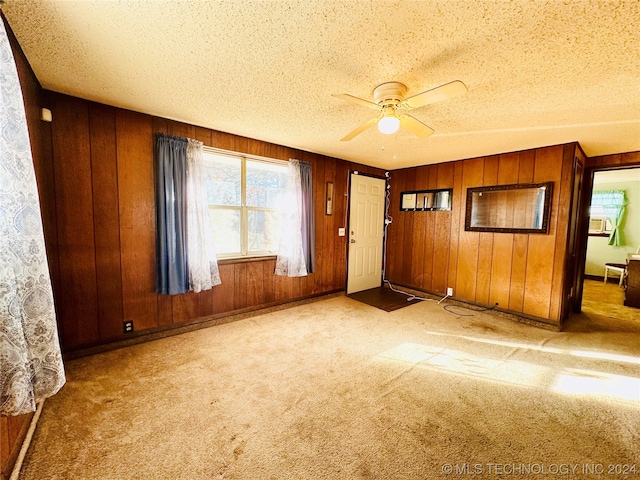 empty room featuring ceiling fan, a textured ceiling, and light carpet