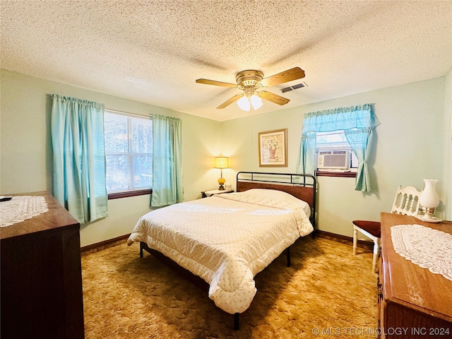 bedroom with carpet floors, ceiling fan, multiple windows, and a textured ceiling