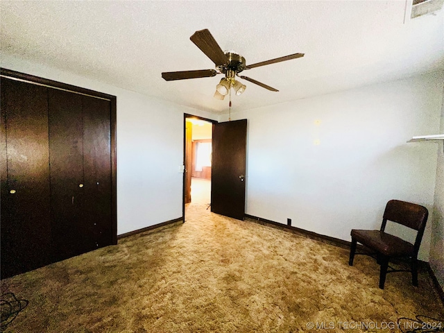 unfurnished room featuring ceiling fan, a textured ceiling, and light carpet