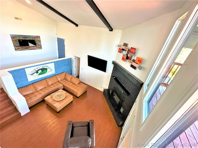 living room featuring a towering ceiling, hardwood / wood-style flooring, and beam ceiling