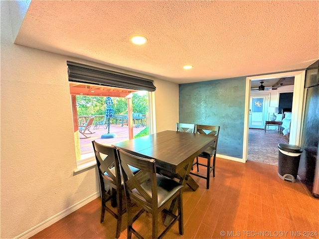 dining space featuring hardwood / wood-style floors, ceiling fan, and a textured ceiling