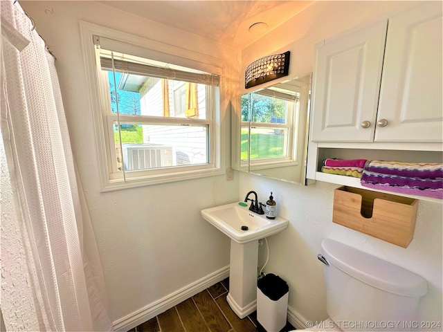 bathroom featuring plenty of natural light, toilet, and hardwood / wood-style floors