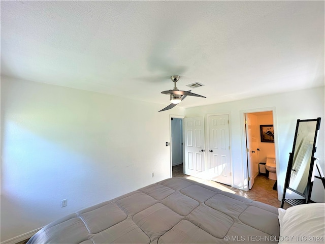 unfurnished bedroom featuring ceiling fan and connected bathroom