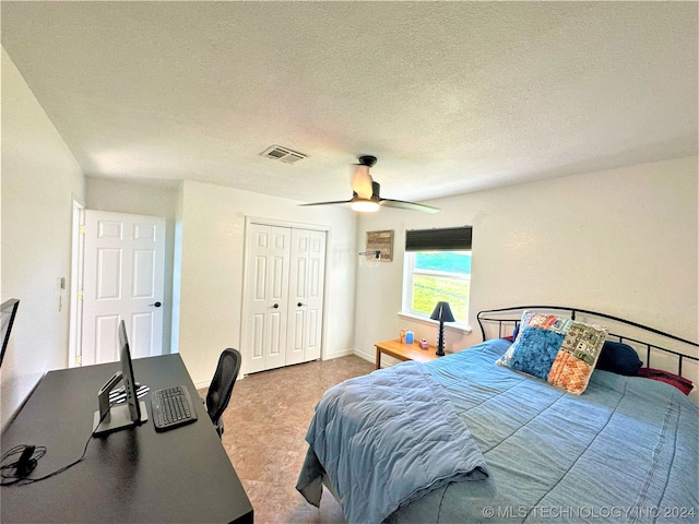 bedroom with a textured ceiling, ceiling fan, and a closet