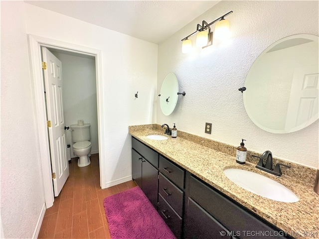 bathroom with vanity, toilet, and hardwood / wood-style flooring