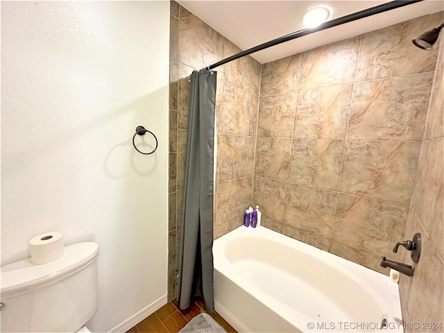 bathroom featuring wood-type flooring, toilet, and shower / tub combo