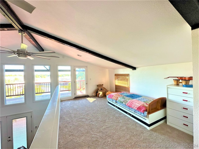 carpeted bedroom featuring a textured ceiling, access to exterior, ceiling fan, and vaulted ceiling with beams