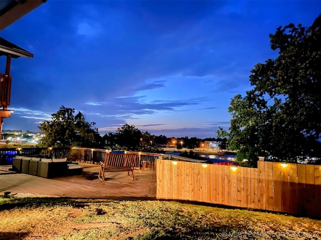 yard at dusk featuring a deck