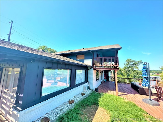 rear view of property featuring a wooden deck and central air condition unit