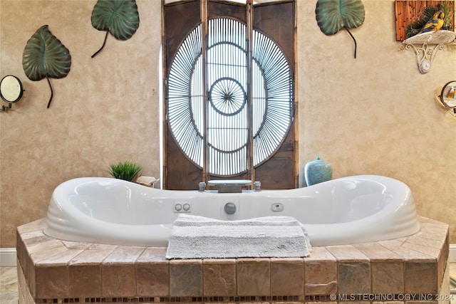 bathroom with a relaxing tiled bath