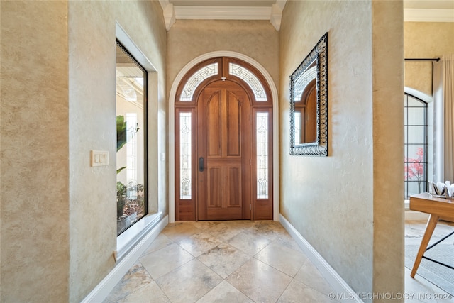 tiled foyer featuring ornamental molding