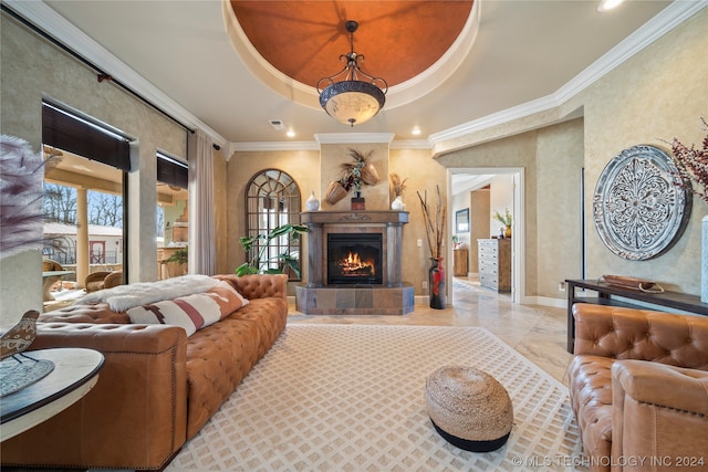 tiled living room with a tile fireplace, crown molding, and a raised ceiling