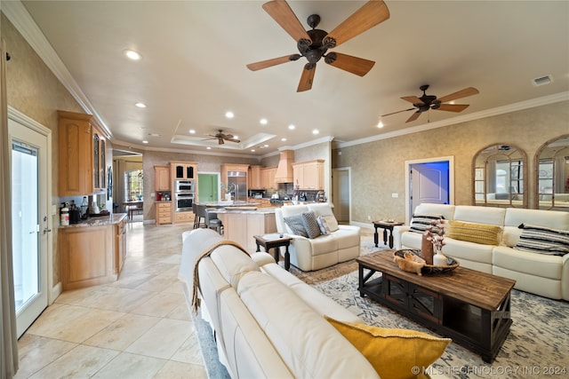 tiled living room with ceiling fan, crown molding, plenty of natural light, and a tray ceiling