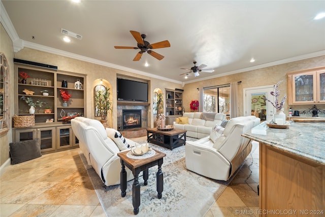 living room featuring ceiling fan, crown molding, a fireplace, and light tile floors