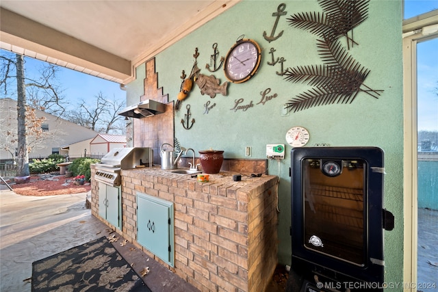 view of patio with exterior kitchen, sink, and a grill