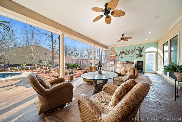 sunroom / solarium with ornate columns and ceiling fan