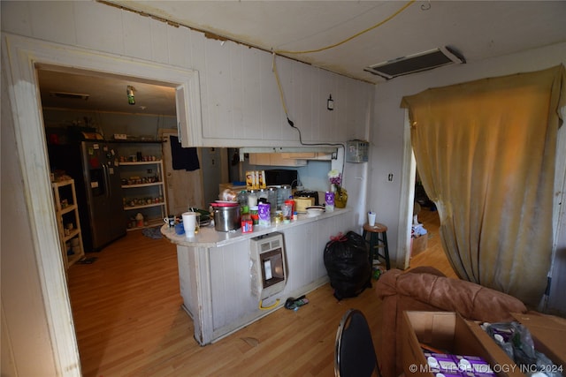 kitchen with light hardwood / wood-style flooring and fridge with ice dispenser