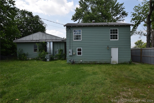 rear view of property featuring a yard