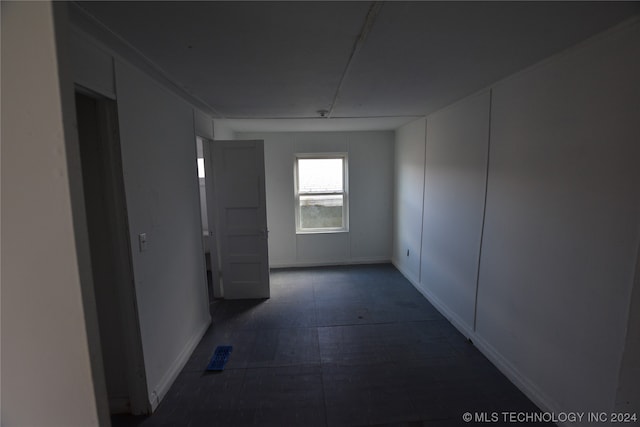 corridor featuring dark tile floors