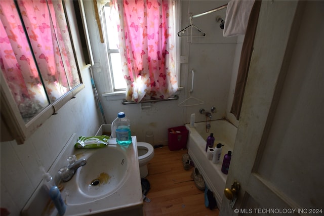 full bathroom featuring toilet, sink, hardwood / wood-style flooring, and bathtub / shower combination