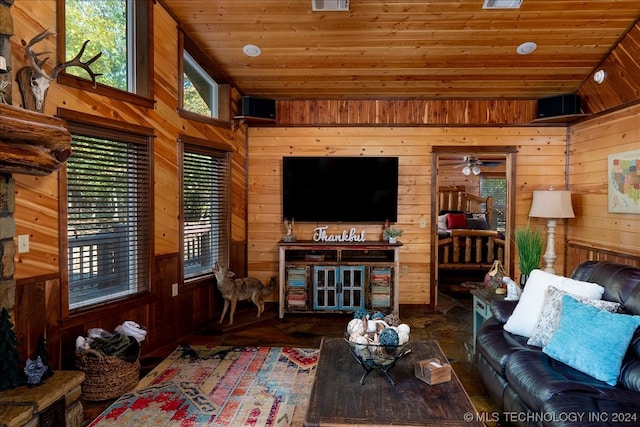 living room featuring wood walls, vaulted ceiling, wooden ceiling, and ceiling fan