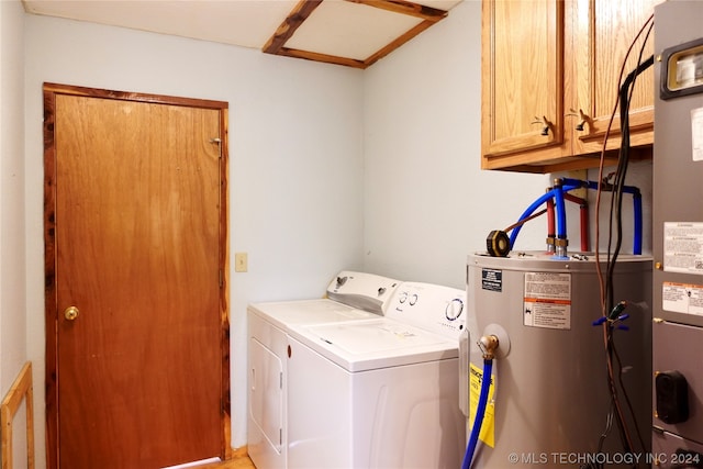 washroom with cabinets, water heater, and washer and dryer