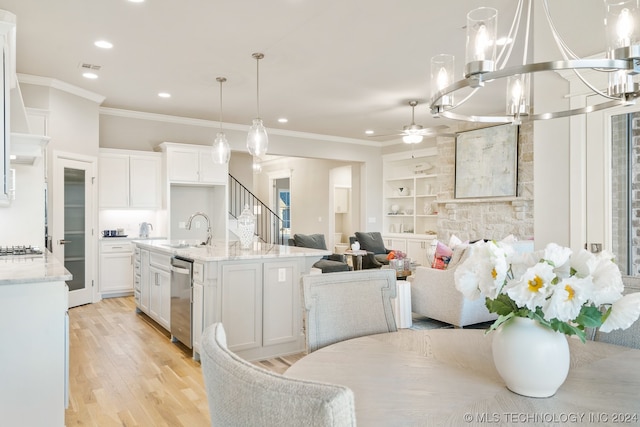 kitchen featuring hanging light fixtures, ceiling fan with notable chandelier, white cabinetry, and light stone counters