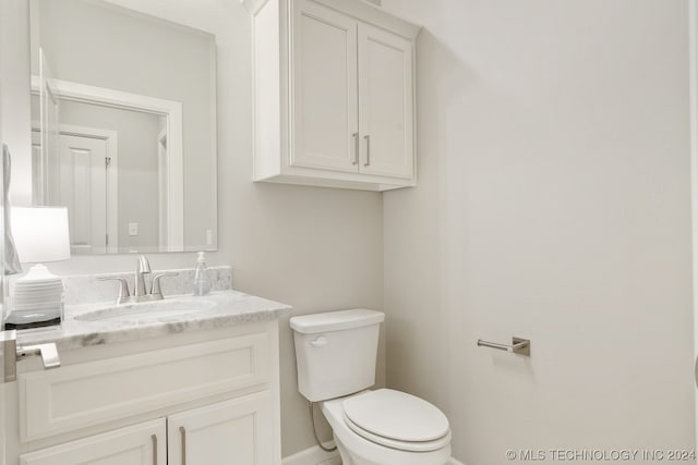 bathroom with toilet and large vanity