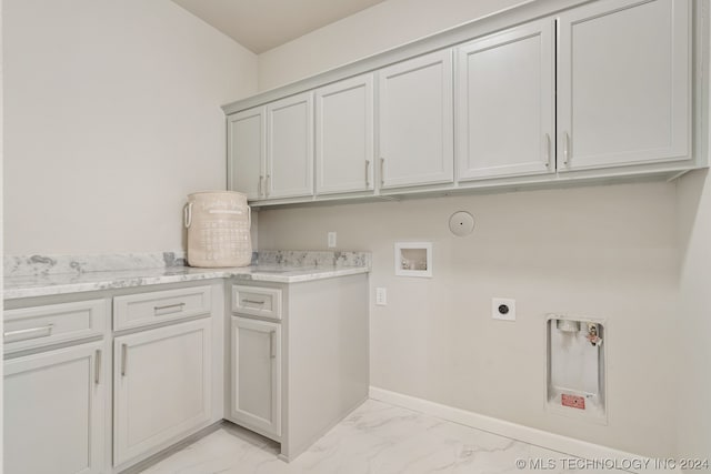 washroom featuring light tile flooring, electric dryer hookup, hookup for a gas dryer, cabinets, and hookup for a washing machine