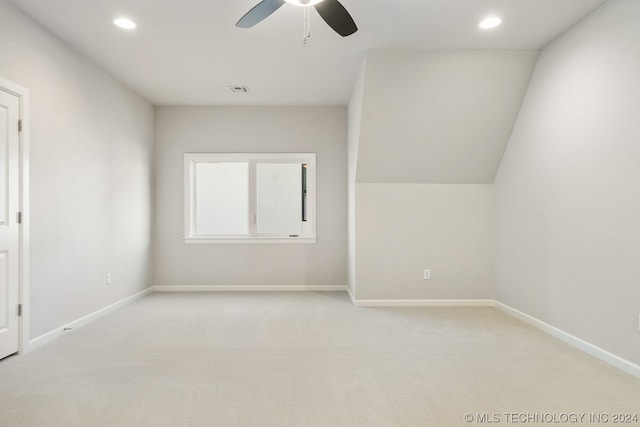 additional living space featuring ceiling fan, lofted ceiling, and light colored carpet