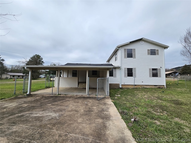 back of house with a lawn and a carport