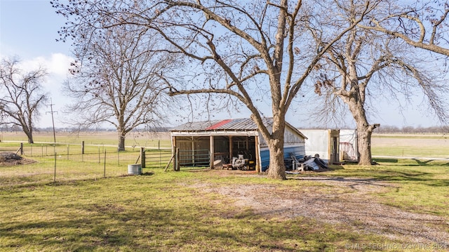 view of yard with central AC and a rural view