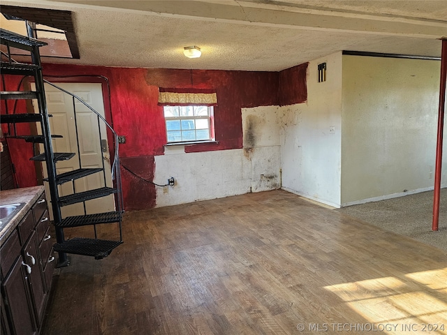 unfurnished room with a textured ceiling and hardwood / wood-style flooring