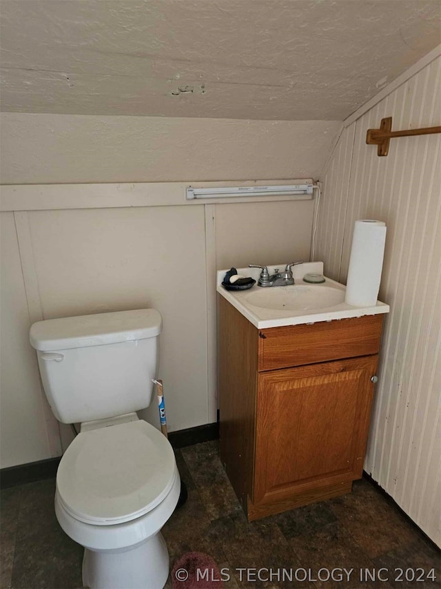 bathroom featuring tile floors, lofted ceiling, toilet, and vanity