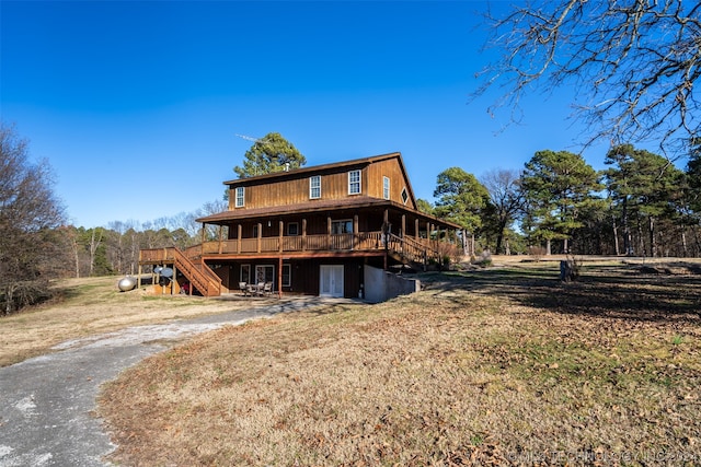 rear view of house with a lawn and a deck