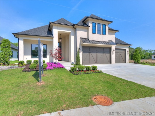 view of front of property with a garage and a front lawn