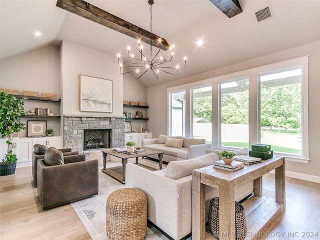 living room with light hardwood / wood-style floors, a fireplace, a wealth of natural light, and an inviting chandelier